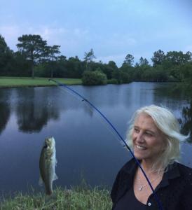 una mujer está sosteniendo un pez en una caña de pescar en DoubleAcres, en Saucier