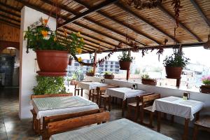 un restaurante con mesas, sillas y macetas en Nazar Hotel, en Selçuk