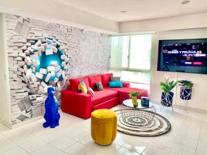 a living room with a red couch and a stone wall at 3 Recámaras Con Diseño Único En "Uno Urban Life" in Guadalajara