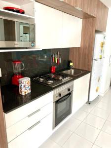 a kitchen with white cabinets and a stove top oven at 3 Recámaras Con Diseño Único En "Uno Urban Life" in Guadalajara +42 photos