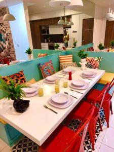 a table in a restaurant with red chairs and plates at 3 Recámaras Con Diseño Único En "Uno Urban Life" in Guadalajara