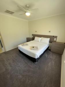 Schlafzimmer mit einem großen weißen Bett und einer Decke in der Unterkunft Coghill House in Yarrawonga + 23 Fotos