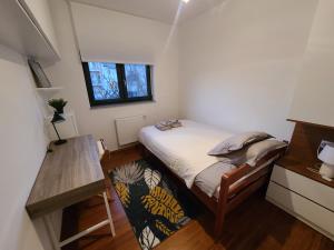 Dormitorio pequeño con cama y mesa en Modern 4-Star luxury apt - WFH Ready, Free Parking, en Zagreb