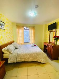 1 dormitorio con 1 cama, vestidor y ventana en Hostal Grand Rio, en Baños