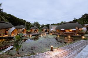 a large swimming pool with a bunch of buildings at Turtle Bay Eco Luxe Hua Hin in Khao Tao