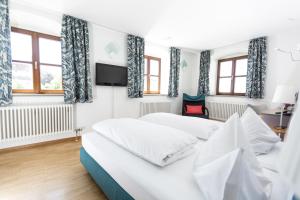dwa łóżka w pokoju z telewizorem i oknami w obiekcie Hotel Klostergasthof w mieście Thierhaupten
