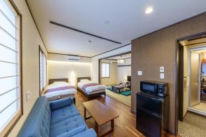 a living room with a blue couch and a bedroom at YADOYA 梟 in Tokyo