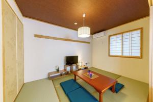 a living room with a wooden table and blue chairs at YADOYA Fukurou in Tokyo