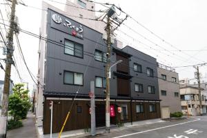 a black building with a sign on the side of it at YADOYA 梟 in Tokyo