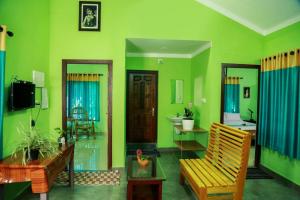 una sala de estar verde con silla y lavamanos en Puzhayoram home stay, Palakkuli, Mananthavadi wayanad kerala en Mananthavady