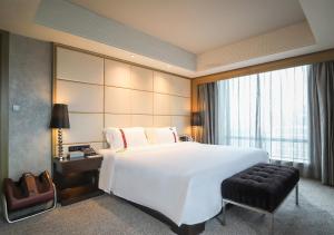 A bed or beds in a room at Rhombus Park Aura Chengdu Hotel