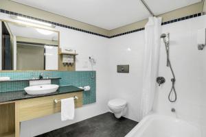 a bathroom with a sink and a toilet and a shower at Kingfisher Bay Resort in Fraser Island