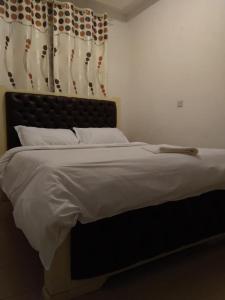 a bedroom with a large bed with a black headboard at Lux Suites Mara Holiday Homes in Narok