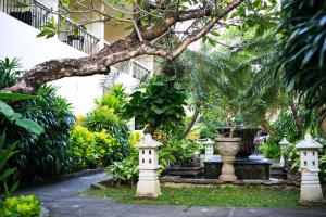 a garden with a tree and two bird houses at Legian Paradiso Hotel in Legian