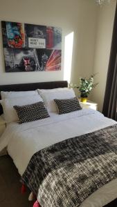 a bedroom with a bed with white sheets and pillows at Modern city centre 1 bed apartment with gym access & free parking by Lets Relocations in Birmingham