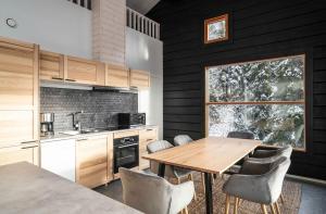 uma cozinha com uma mesa e cadeiras de madeira e uma janela em Villa Ruka - Rising Sun em Ruka