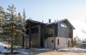a house with a black and white at Villa Ruka - Rising Sun with 3 bedrooms, loft, sauna and balcony with a view in Ruka
