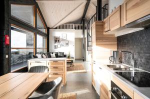 a kitchen with wooden cabinets and a wooden table at Villa Ruka - Rising Sun with 3 bedrooms, loft, sauna and balcony with a view in Ruka