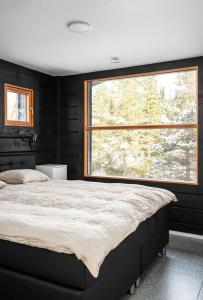 a bedroom with a large bed and a large window at Villa Ruka - Rising Sun in Ruka