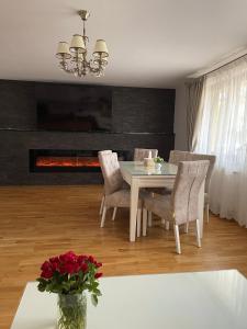 a dining room with a table and chairs and a fireplace at La Mimi Villa in Sadu