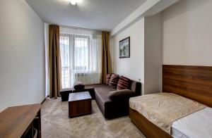 Habitación de hotel con cama y sofá en Hotel Damis, en Pale