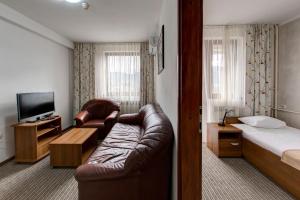 Habitación de hotel con sofá y cama en Hotel Damis, en Pale