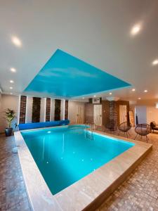 ein Pool in einem Hotel mit einem großen blauen Pool in der Unterkunft Irbēni in Brivkalni