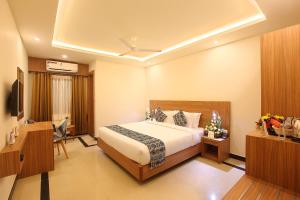 a hotel room with a bed and a television at Hotel Heyday in Pathanāmthitta