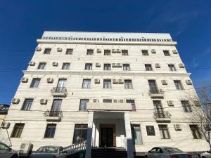 Un gran edificio blanco con ventanas a una calle. en Summer Hotel, en Tashkent