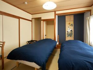 千歳市にあるLY INN CHITOSEAIPORT - Vacation STAY 94792の青い枕2つが備わるベッド1台