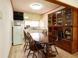 a kitchen with a table and chairs and a refrigerator at LY INN CHITOSEAIPORT - Vacation STAY 94792 in Chitose