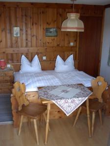 Schlafzimmer mit einem Bett, einem Tisch und Stühlen in der Unterkunft Gästehaus Lickert Familie Dreher in Hinterzarten