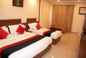 格德拉Hotel The Vaishno Devi Hills的有两张床和一把椅子的酒店房间