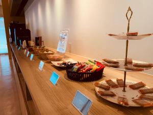 a long wooden table with plates of food on it at Hotel Tenjin Place in Fukuoka