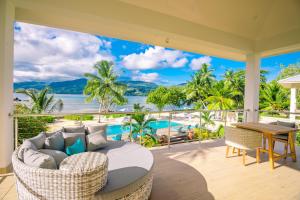 a living room with a view of the ocean at Pineapple Beach Villas in Baie Lazare Mahé