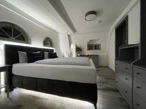 ein Schlafzimmer mit einem großen Bett und einer Kommode in der Unterkunft Alter Kornspeicher in Havelberg