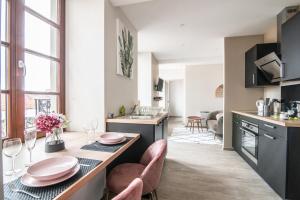 a kitchen with a table with pink plates on it at Centre - Le Contemporain - Parking in Drulingen