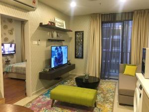 uma sala de estar com uma televisão, um sofá e uma cama em i-Suite, i-City by Mohas Homes em Shah Alam