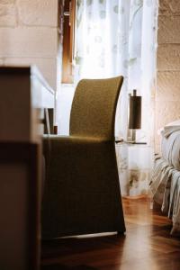 a chair sitting on a wooden floor in a room at Santa Rosa Relais in Noci