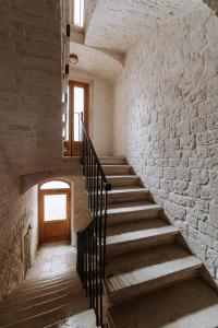 a staircase in an old building with a brick wall at Santa Rosa Relais in Noci