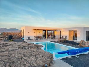 einem Pool mit Wasserrutsche vor einem Haus in der Unterkunft Villa Tabaiba en Lajares con Piscina in Lajares