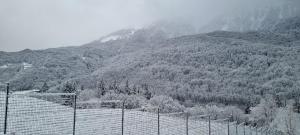 a snow covered mountain with a fence in front of it at Namaste Aparthotel in Krasnaya Polyana