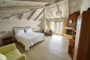 - une chambre avec un lit, un canapé et une cheminée dans l'établissement Hotel Europa Olympia, à Olympie