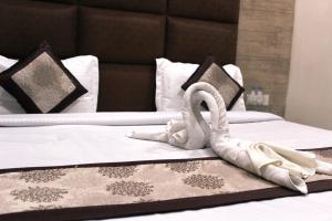 Dos camas con cisnes hechos de toallas. en Shree Krishna Hotels en Amritsar