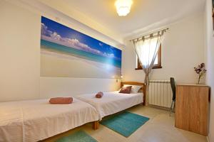 2 camas en una habitación con un cuadro en la pared en Apartment surrounded by a Vineyard, en Tar