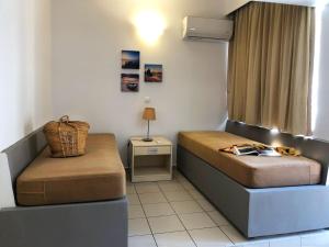 a small room with a bed and a chair at Caravel Hotel Apartments in Ixia