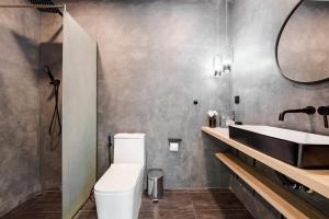 uma casa de banho com um WC branco e um lavatório. em The Beach Village Resort em Sam Roi Yot