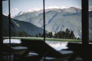 a view of a mountain range through a window at Hotel Milla Montis in Maranza
