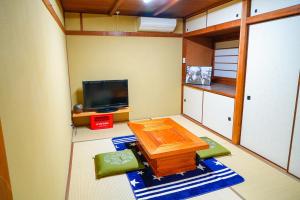 a small living room with a table and a tv at ONE HOSTEL Himeji ワンホステル姫路 in Himeji