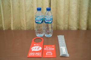 two bottles of water sitting on top of a table at RedDoorz near Bundaran Ciceri in Kumprung